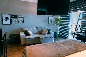 uma sala de estar com um sofá e uma cadeira em Studio a 100m Bosque, Centro e Cambuí- Home Office, Piscina, Sauna, Jacuzzi, Fitness em Campinas