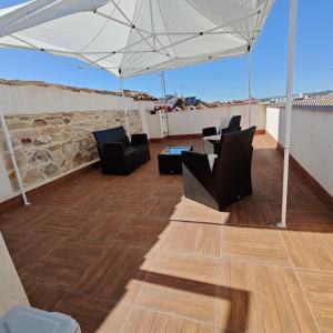 Un patio con sillas y una sombrilla en un tejado. en Casa Casco Antiguo, en Linares