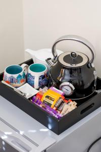 a tea pot and cups on top of a refrigerator at Finest Retreats - Pittodrie Guest House - Room 3 in Brighton & Hove