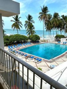 a view of a swimming pool with chairs and the ocean at KASA Poolside Balcony for 2 in San Juan