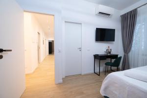 a bedroom with a bed and a desk and a television at Domus Vatican Holiday in Rome