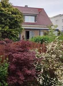 une maison avec une clôture et des fleurs devant elle dans l'établissement Ferienwohnung Muggelig, à Kiel