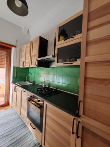 羅馬的住宿－Domus Cornelia，厨房设有绿色瓷砖墙壁和木制橱柜。