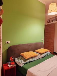 a green bedroom with a bed with two yellow pillows at Domus Cornelia in Rome