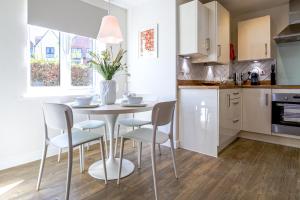 a kitchen with a table and chairs in a kitchen at Fairfields View in Milton Keynes