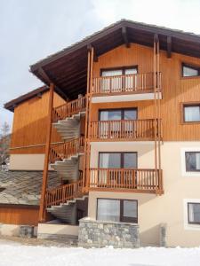 un gran edificio de madera con balcón y escaleras en Au coeur du Parc National de la Vanoise Appart Termignon Val Cenis, en Termignon