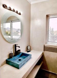 W łazience znajduje się niebieska umywalka i lustro. w obiekcie Sounio Golden View Villas w mieście Sunion +37 zdjęć