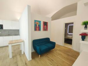 a living room with a blue chair and a table at Andrea's 12 in Bari