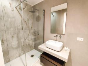 a bathroom with a sink and a glass shower at Andrea's 12 in Bari