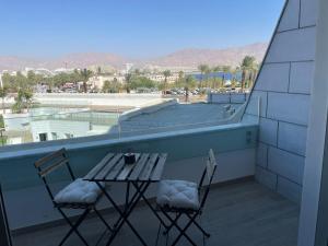 Duas cadeiras e uma mesa numa varanda com vista em oR-Ya Suite em Eilat
