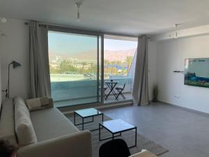 uma sala de estar com um sofá e uma grande janela em oR-Ya Suite em Eilat