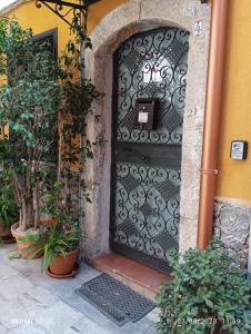 eine schwarze Tür auf einem Gebäude mit Pflanzen in der Unterkunft CASA VACANZE PIEKNY DOM DWA in Taormina