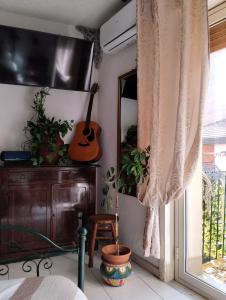 ein Schlafzimmer mit einer Gitarre und einer Kommode neben einem Fenster in der Unterkunft CASA VACANZE PIEKNY DOM DWA in Taormina