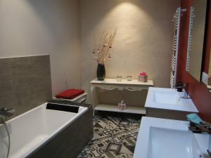 a bathroom with two sinks and a bath tub at Le patio d'antan, le cosy in Florémont