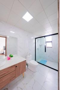 a white bathroom with a shower and a toilet at Zen 3BR Suite near Airport SGR w Pool Gym Restaurant in Nairobi