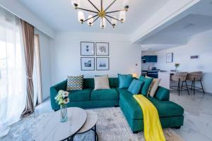 a living room with a green couch and a table at Zen 3BR Suite near Airport SGR w Pool Gym Restaurant in Nairobi