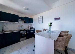 a kitchen with blue cabinets and a vase of flowers on a counter at Zen 3BR Suite near Airport SGR w Pool Gym Restaurant in Nairobi +38 photos