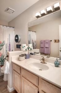 uma casa de banho com um lavatório e um espelho grande em Fountain Hills Bungalow West em Fountain Hills