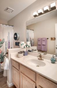 a bathroom with a sink and a large mirror at Fountain Hills Bungalow West in Fountain Hills
