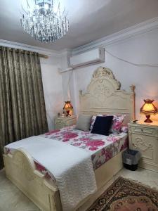 a bedroom with a large bed with a chandelier at Fabulous Apartment in Sheraton Heliopolis ,5 minutes from Cairo Airport in Cairo