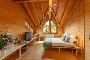 a bedroom in a log cabin with a bed and a tv at Panoramic Chalet Hot Tub, BBQ, view, terrace in Gönnersdorf