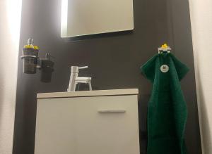 a bathroom with a green towel hanging over a sink at Apartment 3 Tannen in Russbach am Pass Gschütt +14 photos