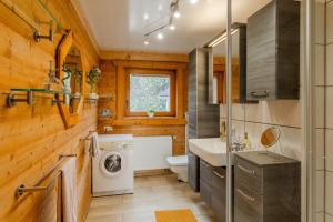 a bathroom with a washing machine and a sink at Panoramic Chalet Hot Tub, BBQ, view, terrace in Gönnersdorf