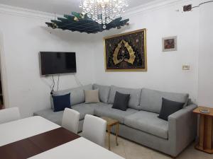a living room with a couch and a flat screen tv at Fabulous Apartment in Sheraton Heliopolis ,5 minutes from Cairo Airport in Cairo