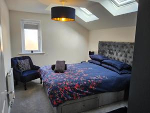 a bedroom with a bed and a chair in it at 5 Star Luxury Small Cosy House with Lake View in Doncaster