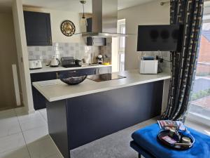 a kitchen with a counter and a blue stool at 5 Star Luxury Small Cosy House with Lake View in Doncaster