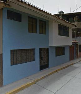 a blue and white house with boarded up windows at Samana Wasi, Lugar encantador en Cusco in Cusco