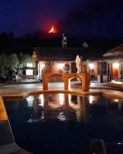a swimming pool in front of a house at night at Terre Villa Katia in Santa Maria di Licodia