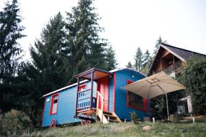 ヴォロネツにあるRED Tiny Housesの傘を前に置いた青い家
