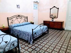 a bedroom with two beds and a dresser and a mirror at Etna in Belpasso