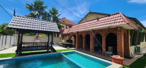 a house with a swimming pool in front of a house at Mawar 23 Chendering with Private Pool in Kuala Terengganu