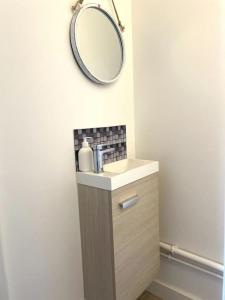 Un baño con un lavabo y un espejo en la pared. en Duplex Bord De Mer, en Le Croisic 8 fotos más