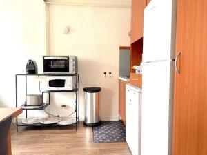 a kitchen with a microwave and a refrigerator at Duplex Bord De Mer in Le Croisic