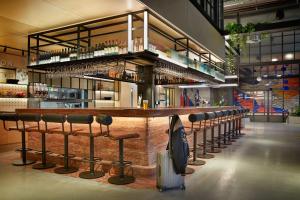 un bar in un edificio con un mucchio di sgabelli da bar di Moxy Sydney Airport a Sydney