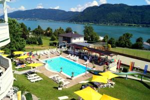 uitzicht op een groot zwembad met gele parasols bij All Inclusive Hotel Sonnenhügel in Sattendorf
