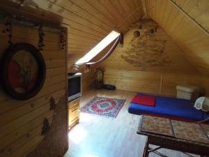 an attic room with a blue bed and a tv at Pokoje Jola Zakopane in Zakopane