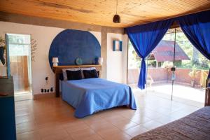 a bedroom with a bed and a large window at Oca Roça in Delfim Moreira