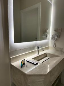 a bathroom with a sink and a large mirror at أجنحة هدوء وصول ذاتي in Al Madinah