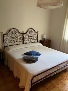 una camera da letto con un grande letto con un cuscino blu di Alloggio MARIPOSA a Borgo San Dalmazzo