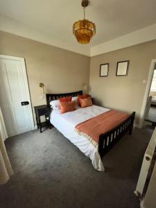 a bedroom with a large bed with orange pillows at Cottage in Whalley in Whalley