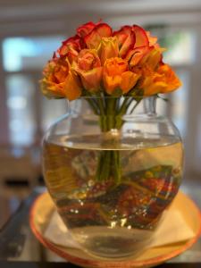 a vase filled with orange flowers sitting on a table at The White Knight Premium Boutique Hotel in Għajnsielem