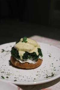 a sandwich with cream cheese and greens on a plate at The White Knight Premium Boutique Hotel in Għajnsielem