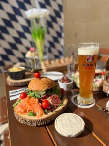 a table with a sandwich and a glass of beer at The White Knight Premium Boutique Hotel in Għajnsielem