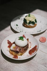 two plates of food on top of a table at The White Knight Premium Boutique Hotel in Għajnsielem