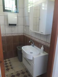 a bathroom with a white sink and a toilet at Quiet & Cosy Hillside Hideway Near Bus & Train St in Sarajevo