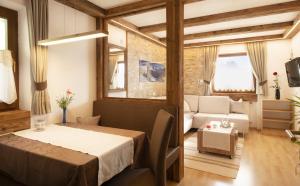 a room with a bed and a living room at Apartments Rondula Pic in Santa Cristina in Val Gardena